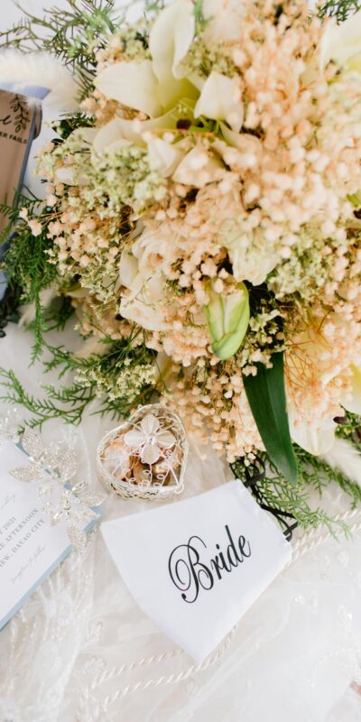 A beautifully arranged bridal setup with a floral bouquet, elegant shoes, and wedding accessories.