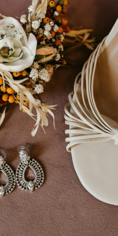 Wedding accessories including sandals, earrings, and a floral bouquet in a stylish flat lay.